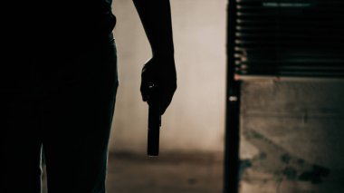 Silahlı, siyah gömlekli bir suçlu soyguncu konseptinin kapısını kırıyor..