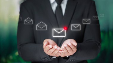 Siyah takım elbiseli iş adamı e-posta simgesi tutuyor. E-posta bülteniyle bizimle irtibata geçin ve kişisel bilgilerinizi spam fikirlerinden koruyun..
