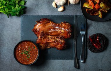 Ev yapımı rosto faresi, biftek bıçağı, çatal, sos, biftek bıçağı, patates dilimleri koyu gri renkli bir tahta üzerinde üst tabaka, eski buruşuk kağıt. Yukarıdan yatay manzara, ızgara fareler..