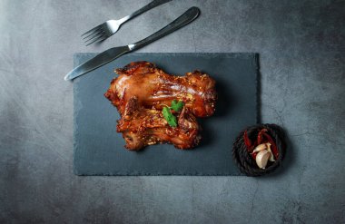 Ev yapımı rosto faresi, biftek bıçağı, çatal, sos, biftek bıçağı, patates dilimleri koyu gri renkli bir tahta üzerinde üst tabaka, eski buruşuk kağıt. Yukarıdan yatay manzara, ızgara fareler..