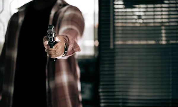 一个身穿条纹衬衫 拿着枪的罪犯破门而入 用枪指着犯罪的概念 — 图库照片