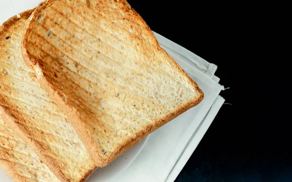 1枚の黒いプレートにトーストしたパンのスライスの山の上のビューの焦点 純白の背景に — ストック写真