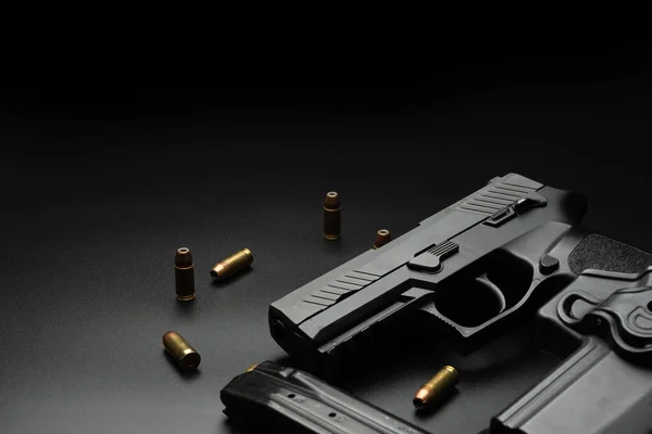 Siyah tabanca koyu bir arka plana yerleştirilir ve etrafına 9 mm 'lik cephane yerleştirilir. Ve dergileri olan bir polis telsizi. Dedektifler için fikir.