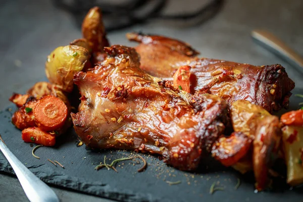 Homemade roast rat, Steak knife, fork, dipping sauce, steak knife, potato wedges close up on a slate board with dark gray color paint, old crumpled paper. Horizontal top view from above,grilled rats.