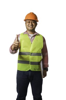 Başlık takan yakışıklı bir baş mühendisin portresi. Yansıtıcı bir kaplan giyiyor. Başparmaklar yukarı. Beyaz arkaplan kırpma yolunda izole edildi.