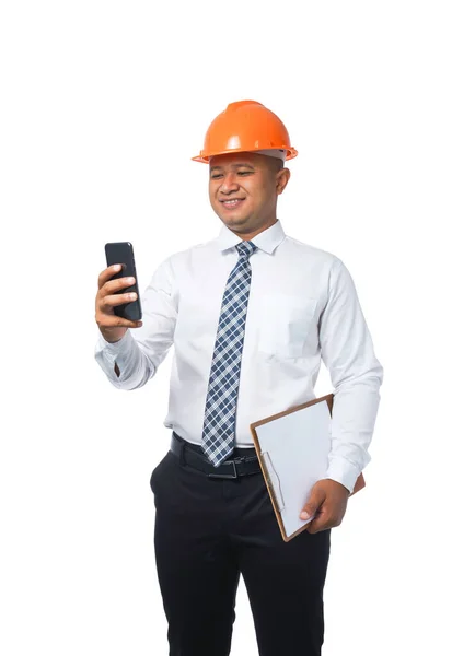 Młody Inżynier Lub Architekt Stojący Trzymając Schowek Telefon Komórkowy Uśmiechnięty — Zdjęcie stockowe