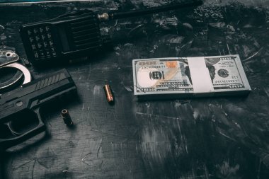Siyah tabancalar, kelepçeler, kurşunlar, dolar banknotları ve polis telsizleri. Siyah ahşap bir masaya yerleştirilmiş. Yolsuzluk polisi kavramı. coppy alanı ile