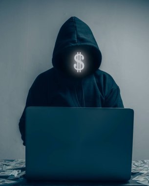 The hacker is wearing a black hoodie. They are stealing huge financial data on computers and have lots of dollars lying around.