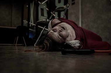 Close-up: A woman in a red dress is bound and bound to a chair to her death horribly in an old gray-black room. Concept of kidnapping, prostitution, and hostage. with copy space.