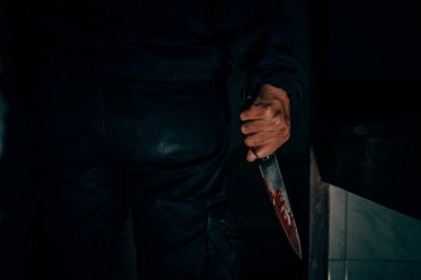 Behind the murderer, he held a blood-stained knife that killed his victim in a very terrifying and terrifying way.