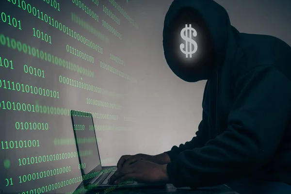 The hacker was wearing a black hoodie. Stealing huge financial data on computers with binary code digital interface and lots of falling dollars and lying on the table.Hacking and malware concept.