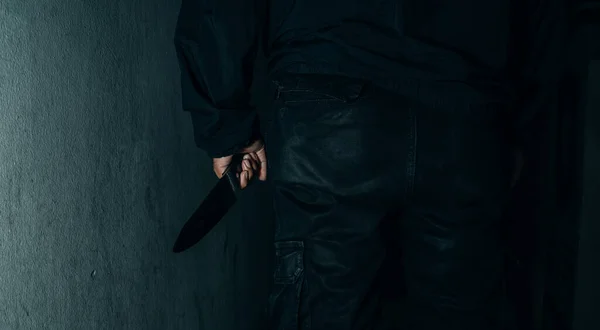 Behind the murderer the man held a bloody knife that killed the victim. horribly and terrifying