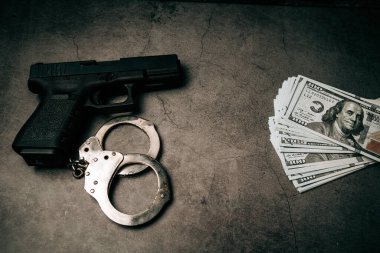 Criminal money. Pistol. Handcuffs and dollar bills. Top view. Mafia and corruption concept. black money and protection