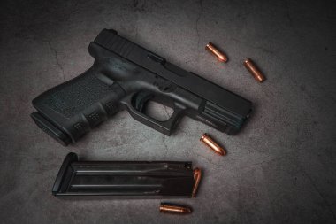 9 mm 'lik siyah bir tabanca ve yanında da 9 mm' lik mermiler vardı. en üstteki görünüm