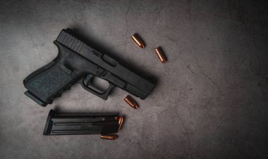 9 mm 'lik siyah bir tabanca ve yanında da 9 mm' lik mermiler vardı. en üstteki görünüm