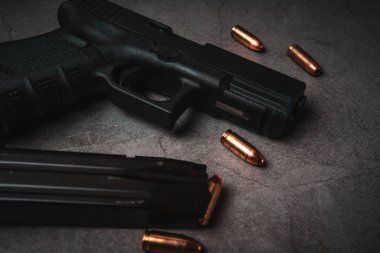 9 mm 'lik siyah bir tabanca ve yanında da 9 mm' lik mermiler vardı. en üstteki görünüm