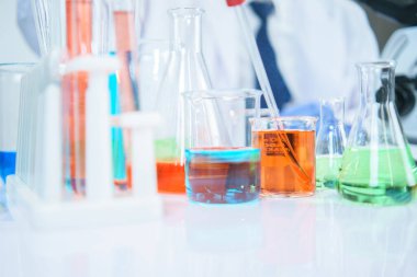 Asyalı bilim adamları laboratuvarda kimyasal bileşenleri ciddi şekilde inceliyorlar. Genç Biyoteknoloji Uzmanlığı Gelişmiş mikroskop ekipmanları kullanın.