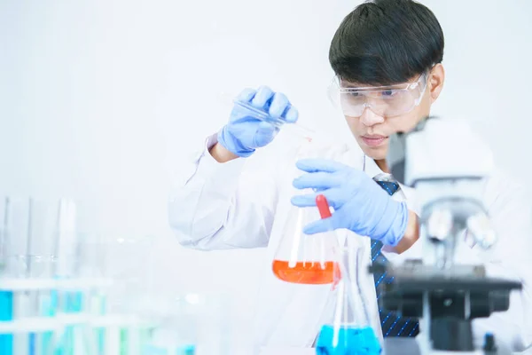 Asian scientists are seriously studying the chemical composition in the laboratory. Specializing in Young Biotechnology Use advanced microscope equipment.