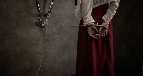 Back view of woman in red dress standing in dark room. Concept horror, scary, ugly, woman.