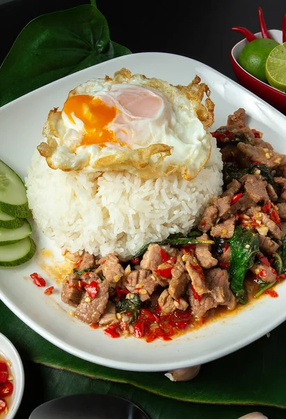 Stir-fried beef and basil Thai Food Rice topped with egg, famous street food in Thailand, fast food, soft focus.