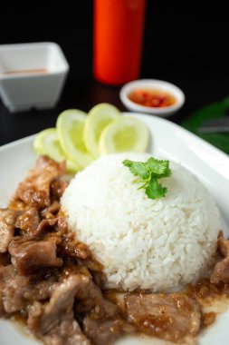 Stir-fried pork with garlic and pepper, and sliced cucumber served with jasmine rice, a white dish, a popular Thai dish