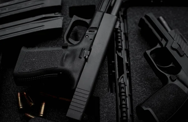 Two 9mm pistols hold slides on a wooden table.