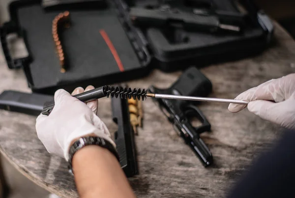 Gunsmith Sitting Cleaning Gun Disassembling Maintaining Pistol Fotos de stock libres de derechos