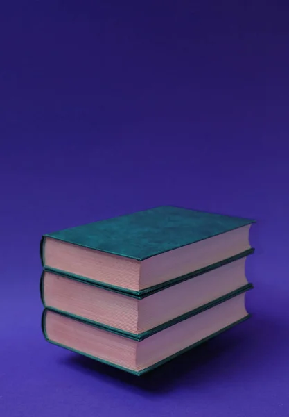 Drei Bücher Gebunden Waagerecht Übereinander Gestapelt Auf Blauviolettem Hintergrund Textraum — Stockfoto