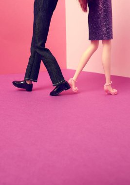 Pembe şeftali rengi arka planda iki bebek ters yöne gidiyor. Metin uzayı. İlişki, boşanma, ayrılma, vücut dili, konsept. Asgari biçim.