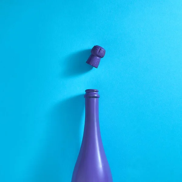 明るい青色の背景にシャンパンとコルクの紫色のボトル テキスト空間 最上階だ ミニマルスタイル — ストック写真