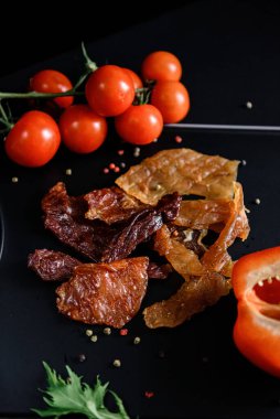 Siyah arka planda domatesli mezeler.