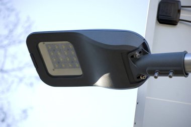 Mavi gökyüzüne karşı güneş paneli tarafından desteklenen lamba.