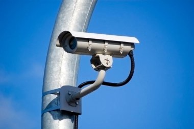 Mavi gökyüzüne karşı şehir izleme sistemi kamerası.