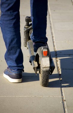 Şehir parkında elektrikli scooter kullanan bir adama yaklaş..