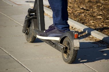 Şehir parkında elektrikli scooter kullanan bir adama yaklaş..