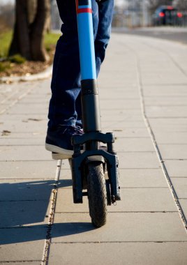 Şehir parkında elektrikli scooter kullanan bir adama yaklaş..