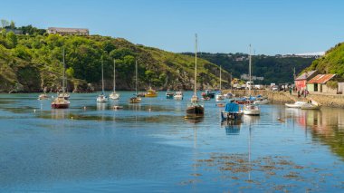 Fishguard, Pembrokeshire, Galler, İngiltere - 20 Mayıs 2017: Denizci botları, arka planda Quay Caddesi 'nde yürüyen insanlar