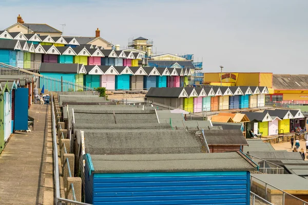 Walton-on-the-Naze, Essex, İngiltere - 29 Mayıs 2017: Southcliff Gezinti Güvertesinde sahil kulübeleri, bazı insanlar ve arka planda Walton İskelesi