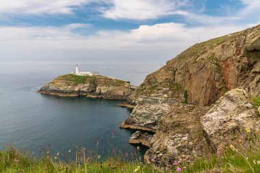 Holyhead, Anglesey, Gwynedd, Galler, İngiltere - 08 Haziran 2018 - Kayalıklara ve Güney Yığını Deniz fenerine doğru bakın