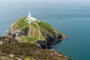 Holyhead, Anglesey, Gwynedd, Galler, İngiltere - 08 Haziran 2018 - Kayalıklara ve Güney Yığını Deniz fenerine doğru bakın