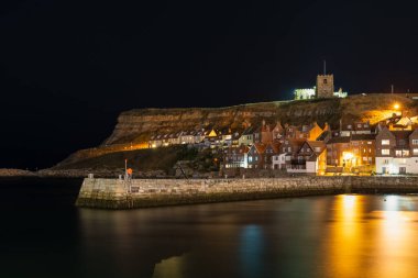 Whitby, North Yorkshire, İngiltere -12 Eylül 2018: Pier Road 'dan Tate Pier ve St. Mary' s 'e doğru akşam manzarası