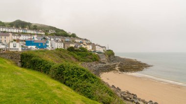 New Quay, Ceredigion, Dyfed, Wales, UK - May 24, 2017: Morning dust over the beach and the village clipart