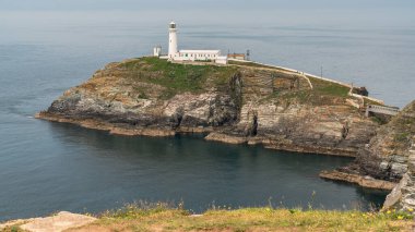 Holyhead, Anglesey, Gwynedd, Galler, İngiltere - 08 Haziran 2018 - Kayalıklara ve Güney Yığını Deniz fenerine doğru bakın