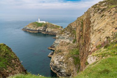 Holyhead, Anglesey, Gwynedd, Galler, İngiltere - 08 Haziran 2018 - Kayalıklara ve Güney Yığını Deniz fenerine doğru bakın