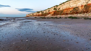 Hunstanton, Norfolk, İngiltere, İngiltere - 25 Nisan 2019: Deniz feneri ve uçurumlar üzerinde akşam ışığı ve bulutları