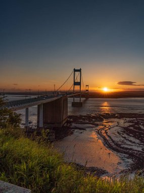 Aust, South Gloucestershire, İngiltere - 08 Haziran 2019: Severn Köprüsü 'nde günbatımı, Severn Nehri' nin üzerinde, Aust Cliff 'ten görüldü.