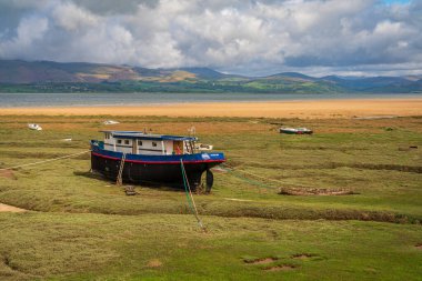 Askam-in-Furness, Cumbria, İngiltere, İngiltere - 2 Mayıs 2019: Arka planda Lake District Ulusal Parkı 'nın üzerinde bulutlar bulunan tekneler