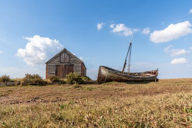 Thornham, Norfolk, İngiltere, İngiltere - 24 Nisan 2019 Thornham Old Harbour 'da yanında ahşap yelkenli teknesi olan eski bir taş ahır