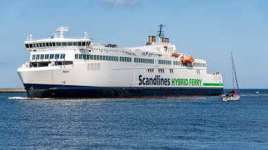 Rostock, Mecklenburg-Batı Pomerania, Almanya - 14 Haziran 2020: Gedser 'den Rostock' a giden bir Scandline feribotu Warnemuende 'deki batı rıhtım fenerinin önünden geçiyor