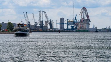 Rostock, Mecklenburg-Batı Pomerania, Almanya - 14 Haziran 2020: Liman yolcu gemisi ve arka planda hasar gören Liebherr ağır kaldırma vinci ile limana bakın
